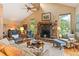 Cozy living room with stone fireplace, vaulted ceiling, and windows offering natural light with mountain views at 207 Kelly E Rd, Boulder, CO 80302