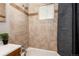 Bathroom with tile surround, window, shower head, and shower curtain at 1941 Wabash St, Denver, CO 80220