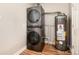 Efficient laundry area with a stacked washer and dryer set, and a water heater at 1941 Wabash St, Denver, CO 80220