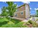 Exterior view of a backyard with green grass, mature trees and a lovely patio at 20145 E Fair Ln, Centennial, CO 80016