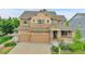 Two-story home featuring a three-car garage, stone accents, and well-maintained landscaping at 20145 E Fair Ln, Centennial, CO 80016