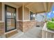 Covered front porch featuring brick accents, a 'Welcome' mat, and a view of the home's entrance at 20145 E Fair Ln, Centennial, CO 80016
