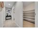 Well-lit hallway with gray flooring leading to powder room and large walk-in pantry at 20145 E Fair Ln, Centennial, CO 80016