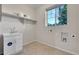 Laundry room features sink, storage shelf and natural light from a large window at 20145 E Fair Ln, Centennial, CO 80016