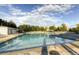 A refreshing community swimming pool with lounge chairs and mature trees against a blue sky at 20145 E Fair Ln, Centennial, CO 80016