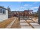 Backyard view of pergola covered patio with table/chairs, and multiple storage sheds at 2415 E Maplewood Ave, Centennial, CO 80121