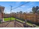 Fenced in back yard features a small patch of green and mature trees at 2415 E Maplewood Ave, Centennial, CO 80121