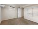 Unfinished basement with carpet, small window, and shelving unit at 2415 E Maplewood Ave, Centennial, CO 80121