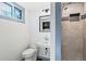 Modern bathroom featuring a shower, toilet, vanity, and window, offering a functional space at 2415 E Maplewood Ave, Centennial, CO 80121