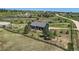 Aerial view of a house with a fenced yard, mature trees, and outbuildings at 36023 Winchester Rd, Elizabeth, CO 80107