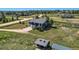 Expansive aerial view of a rural home featuring a vast yard, shed, and surrounding trees at 36023 Winchester Rd, Elizabeth, CO 80107