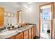 Bathroom with double sinks, granite countertops, wood cabinets, and framed mirrors at 36023 Winchester Rd, Elizabeth, CO 80107