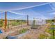 View of a home garden covered in netting, mulch, and several metal garden beds at 36023 Winchester Rd, Elizabeth, CO 80107