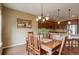 Dining room with wood table, chandelier, and kitchen access at 4784 Raven Run, Broomfield, CO 80023