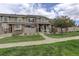 Charming townhome with stone accents, a well-manicured lawn, and a welcoming front porch with rocking chairs at 4784 Raven Run, Broomfield, CO 80023