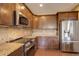 Modern kitchen with stainless steel appliances, granite counters, and ample cabinet space, perfect for cooking enthusiasts at 4784 Raven Run, Broomfield, CO 80023