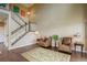 Spacious living room with hardwood floors, a staircase, and comfortable leather armchairs, creating a cozy atmosphere at 4784 Raven Run, Broomfield, CO 80023