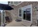 View of stone patio with a chair, umbrella and sliding glass doors for outdoor living and entertaining at 4784 Raven Run, Broomfield, CO 80023