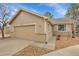 Charming home features a two-car garage, beige siding, and brick accents for added curb appeal at 9585 Brentwood Way # D, Westminster, CO 80021