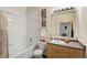 Bright bathroom featuring a tub and shower, a sink and vanity, and a large mirror at 5677 S Park Pl # C208, Englewood, CO 80111