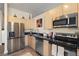 Contemporary kitchen featuring stainless steel appliances, dark countertops, and ample cabinet space at 5677 S Park Pl # C208, Englewood, CO 80111