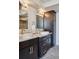 A modern bathroom with double sinks, granite countertops, dark cabinets, and chrome fixtures at 2245 Blake St # C, Denver, CO 80205