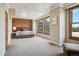 Bedroom with a brick accent wall, platform bed and a view from three large windows at 2245 Blake St # C, Denver, CO 80205