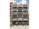 A brick multi-story building with green-trimmed windows, and small balconies outside some windows at 2245 Blake St # C, Denver, CO 80205