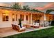 Inviting back patio with string lights, outdoor seating, grill, and manicured lawn perfect for entertaining at 3001 S Josephine St, Denver, CO 80210