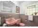 Retro bathroom features pink sink, toilet, and beautiful wall tiling at 3001 S Josephine St, Denver, CO 80210