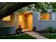 Inviting front porch with decorative trim and well-manicured landscaping and walkway at dusk at 3001 S Josephine St, Denver, CO 80210