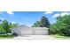 Three car garage with a well maintained concrete driveway and mature trees in the front yard at 3001 S Josephine St, Denver, CO 80210