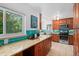 Bright kitchen boasts wood cabinets, granite counters, stainless appliances, and beautiful blue backsplash at 3001 S Josephine St, Denver, CO 80210