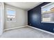 Spacious bedroom with gray and blue walls, carpet flooring, and two windows at 6771 Canosa St, Denver, CO 80221