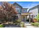 Charming two-story home boasts lush landscaping and a welcoming covered front porch entry at 6771 Canosa St, Denver, CO 80221