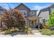 Charming two-story home boasts lush landscaping and a welcoming covered front porch entry at 6771 Canosa St, Denver, CO 80221