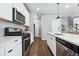 Modern kitchen with white cabinets, island, and stainless steel appliances at 6771 Canosa St, Denver, CO 80221