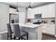 Modern kitchen features stainless steel appliances, white cabinetry, pendant lighting, and a quartz countertop island at 6771 Canosa St, Denver, CO 80221