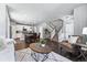 Open-concept living room features hardwood floors, modern furniture, a staircase, and an eat-in kitchen at 6771 Canosa St, Denver, CO 80221