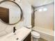 Modern bathroom with geometric tile, vanity with round mirror, tub and shower combo at 5470 Danube St, Denver, CO 80249