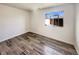 An empty bedroom with wood floors, a bright window, and fresh white walls at 5470 Danube St, Denver, CO 80249