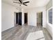 Bright bedroom with wood-look floors, ceiling fan, and multiple doorways at 5470 Danube St, Denver, CO 80249