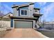 Modern two-story home featuring blue siding, gray garage door, and brick paver driveway at 5470 Danube St, Denver, CO 80249