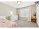 Comfortable bedroom featuring a white dresser, soft lighting, and a window at 60 Stewart Way, Erie, CO 80516