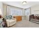 Cozy Bedroom featuring a chair, a dresser, window with blinds, and a crib at 60 Stewart Way, Erie, CO 80516