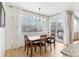 Cozy dining area with modern lighting, large windows, and sliding door to backyard patio at 60 Stewart Way, Erie, CO 80516