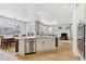 Open kitchen with island, stainless appliances, seamlessly flowing into the living and dining areas at 60 Stewart Way, Erie, CO 80516