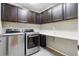 Well-organized laundry room featuring a front-load washer and dryer and ample cabinet space at 60 Stewart Way, Erie, CO 80516