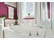 Bright bathroom featuring a soaking tub, white tile, and vibrant accent wall, creating a serene and inviting atmosphere at 2796 Newport Cir, Castle Rock, CO 80104