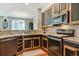 Modern kitchen with stainless steel appliances and dark wood cabinets and open sightlines to dining at 2796 Newport Cir, Castle Rock, CO 80104